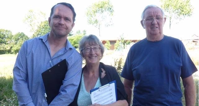 greg burt, keith brown and jean griffin smiling in front of a beautiful garden