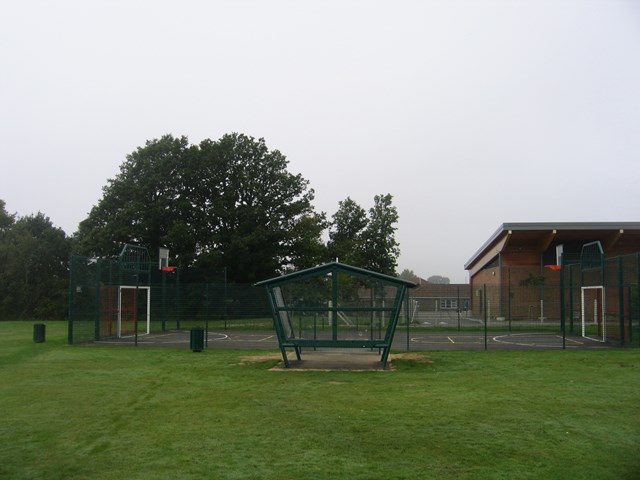 a basketball/football court with trees in the background